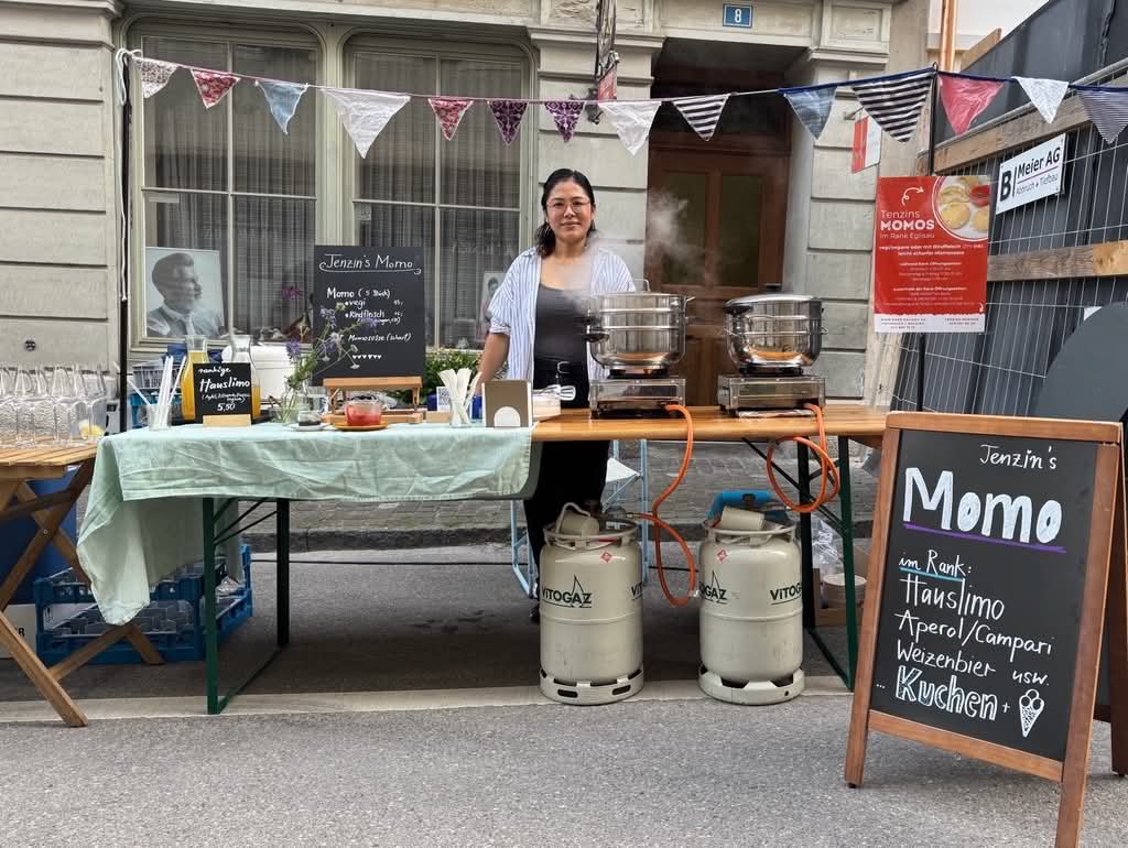 Tenzin Dolma am MomoGo Cateringstand mit dampfenden Momo