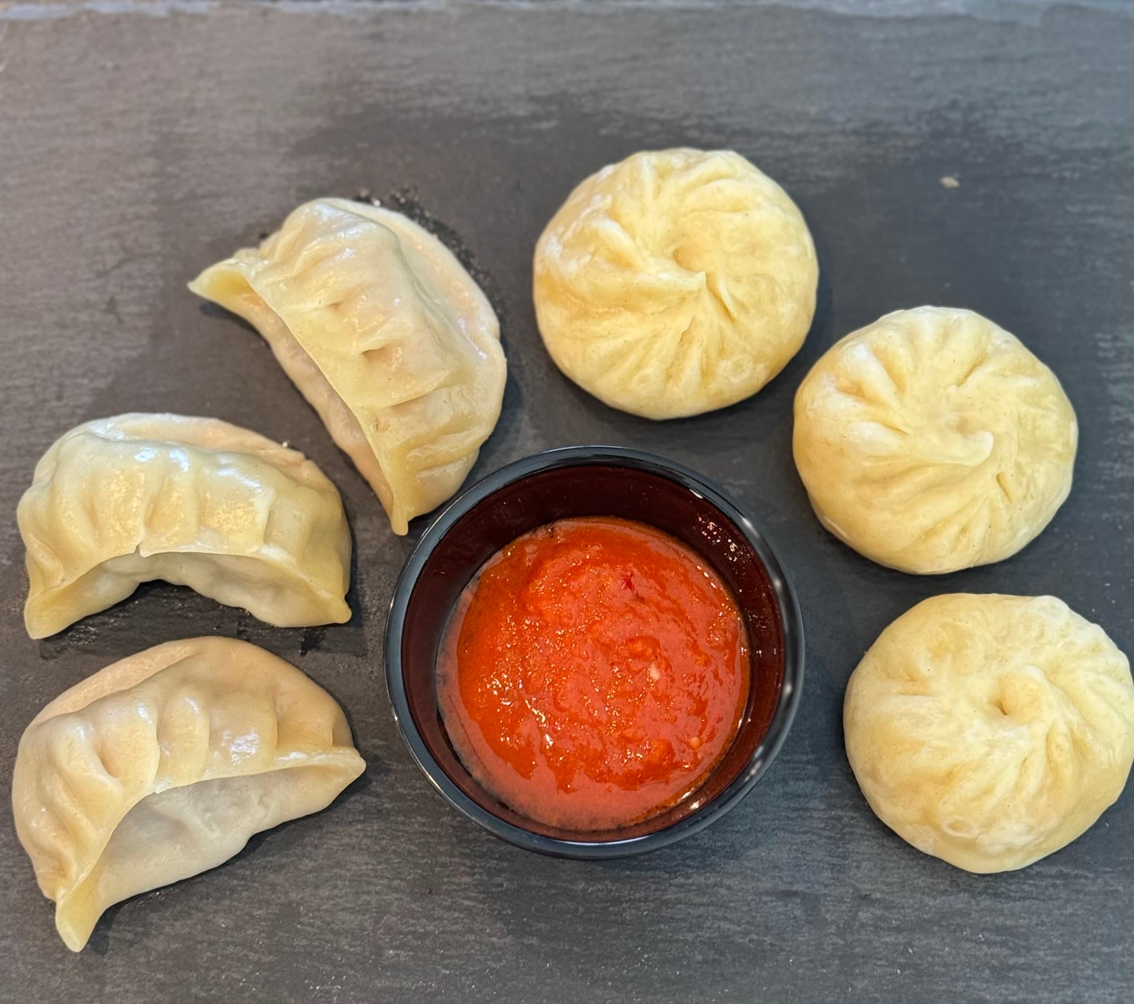 Handgemachte runde und halbmondförmige Momo mit tibetischem Chutney
