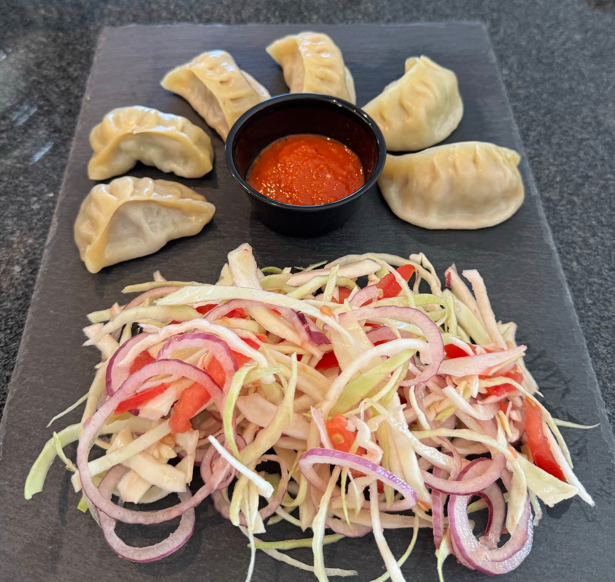 Handgemachte Momo mit tibetischem Chutney und frischem Salat
